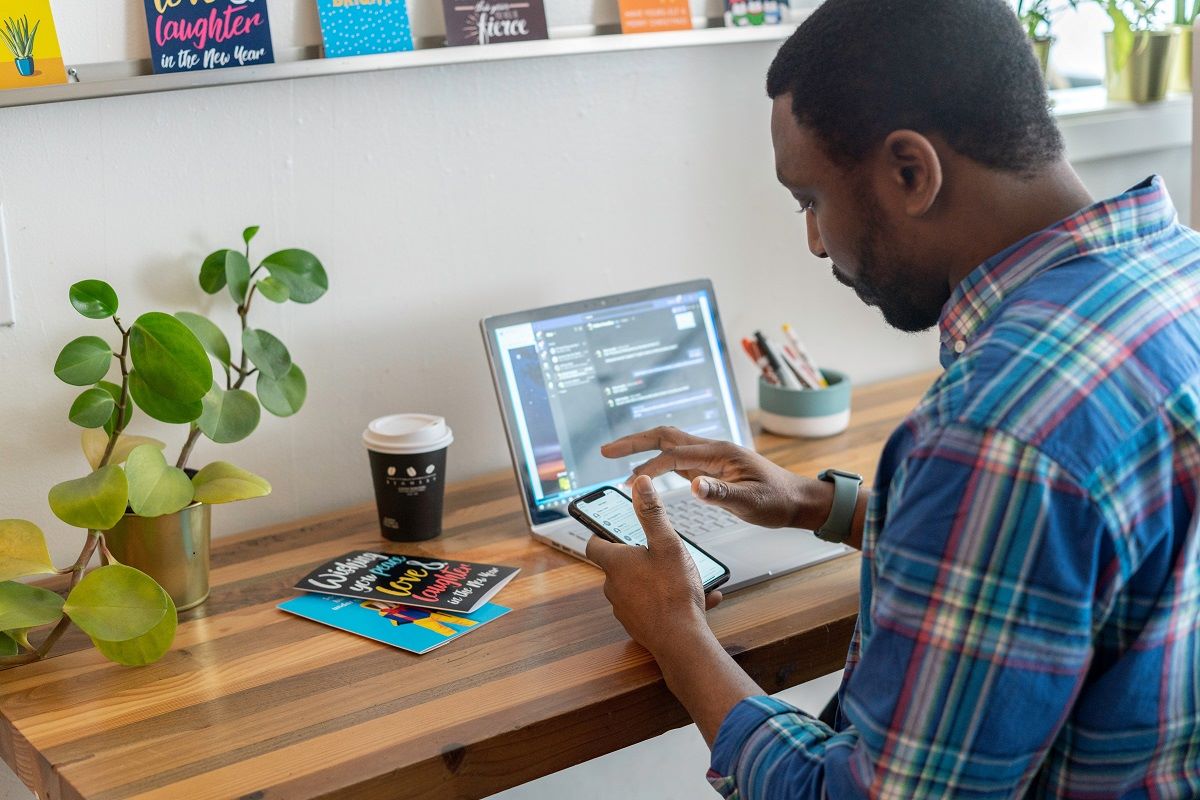 Business owner communicating using a laptop and smartphone