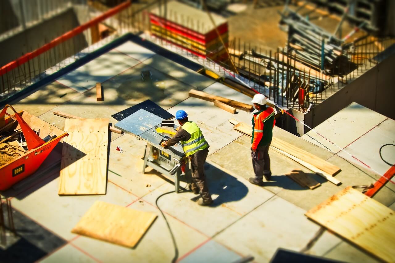 Two men work on a construction site