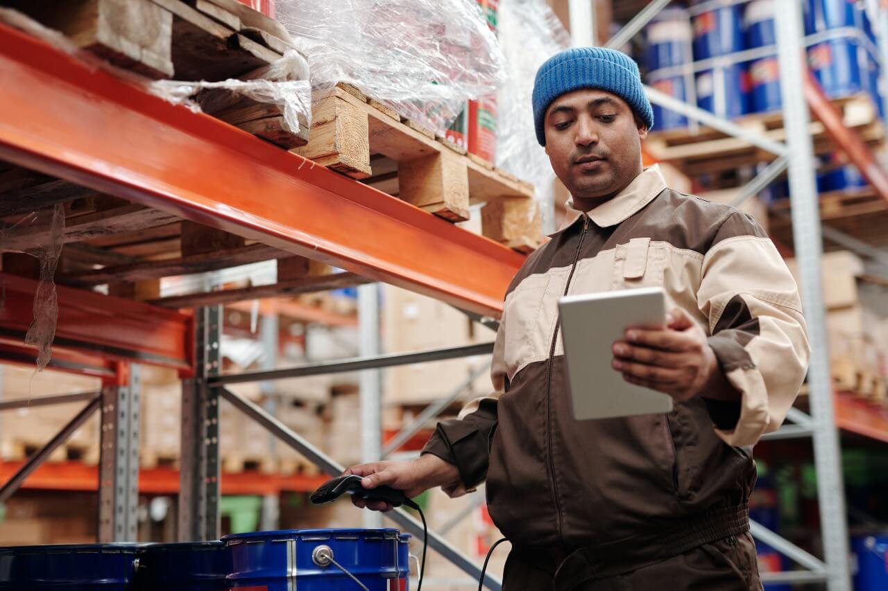 Construction worker wearing blue hat scans product to price up