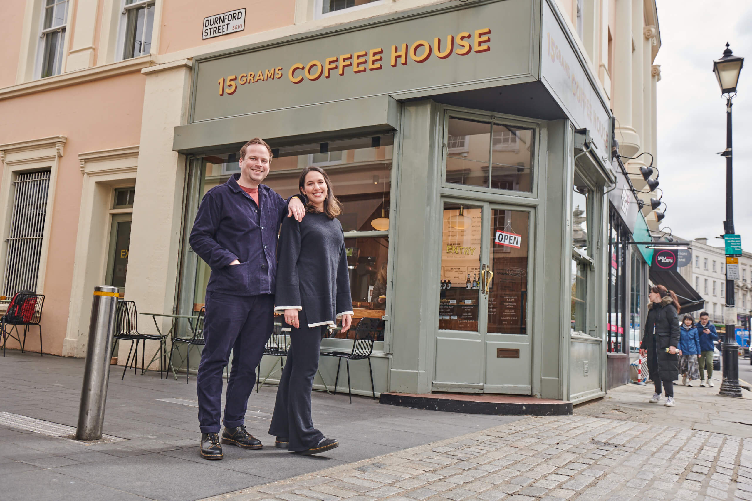 Tide members, Inas and Joe, standing outside their 15grams Coffee House