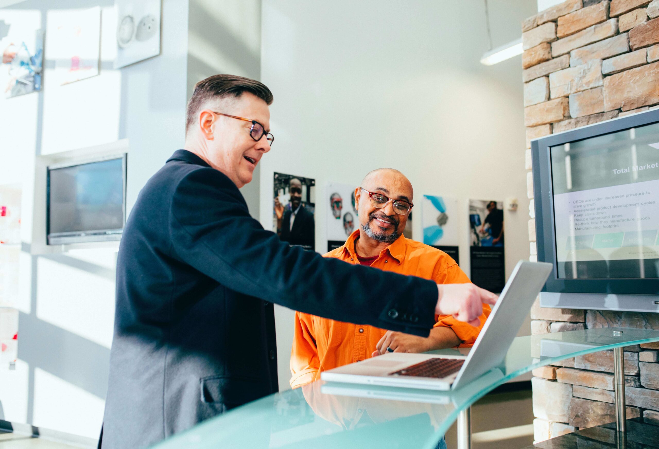 Advisor and client smiling at a laptop in an office