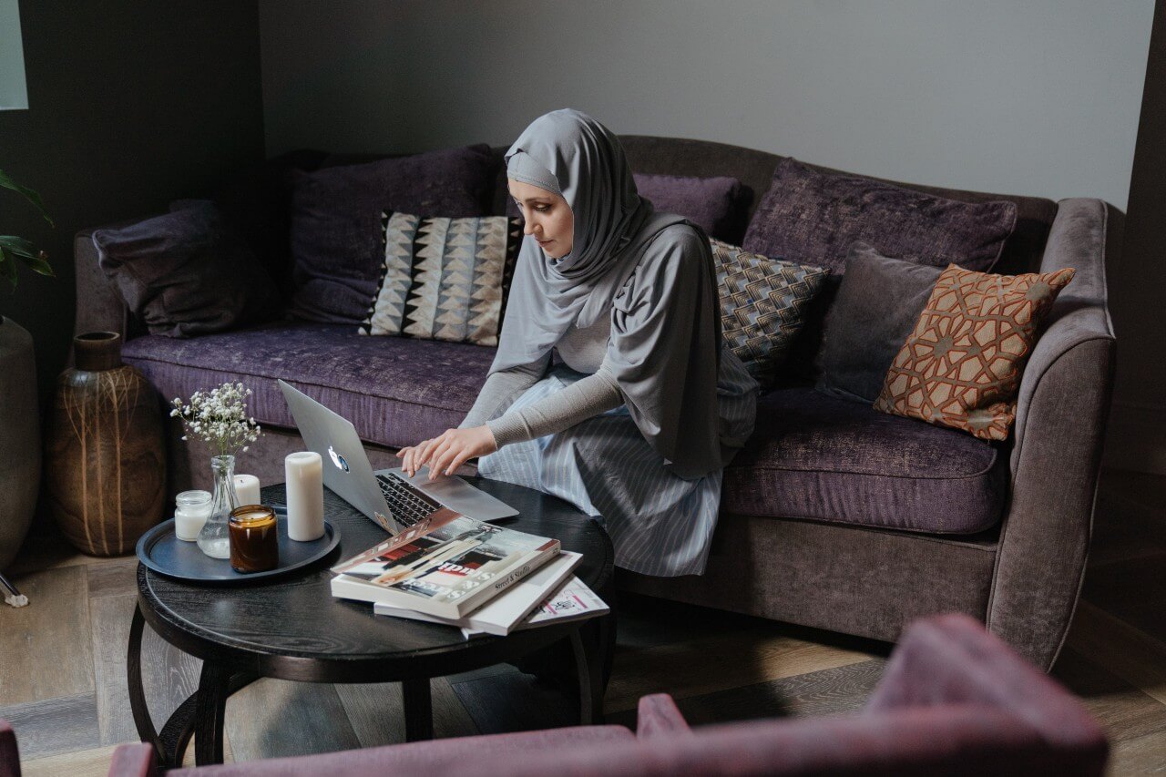 Lady in a grey hijab works at laptop